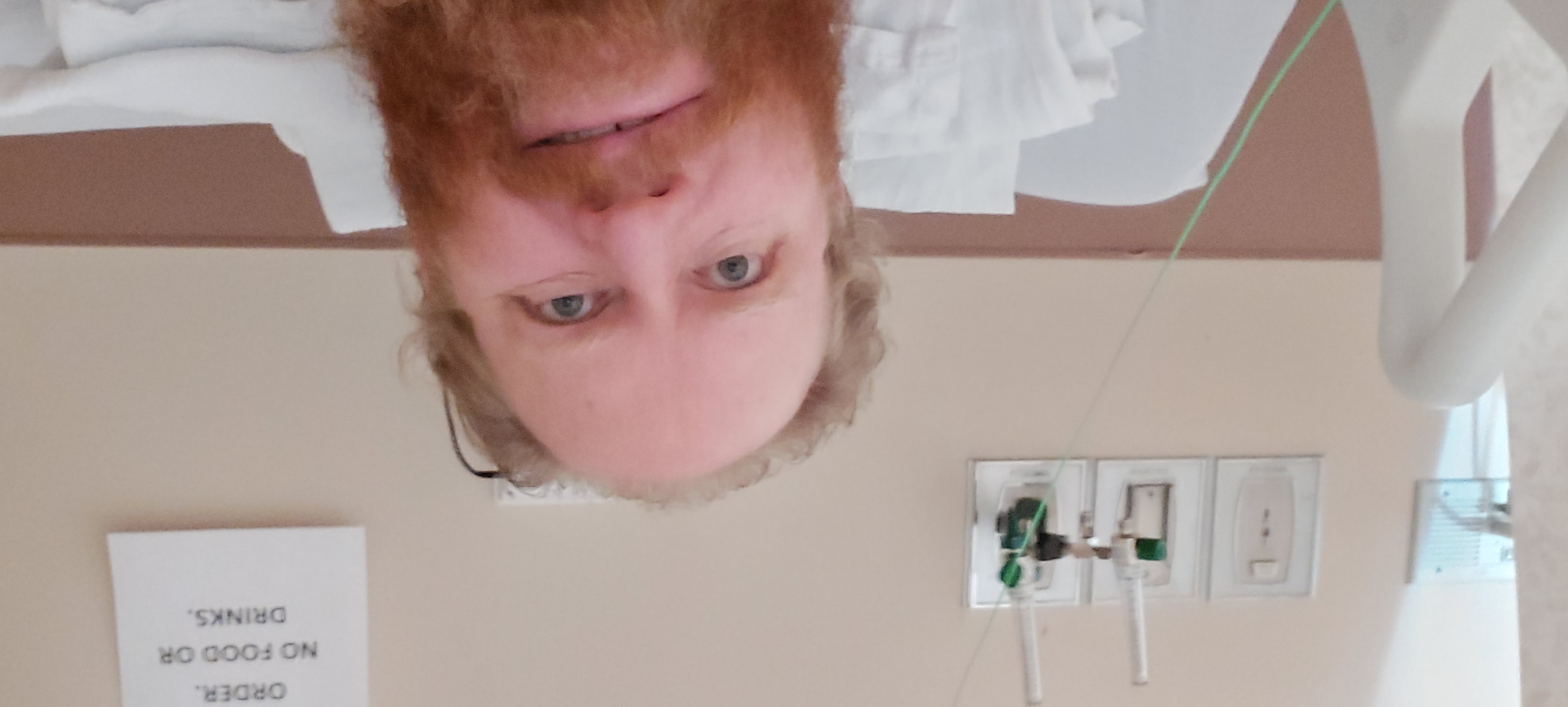 Dennis Alexander in a hospital bed with a frustrated look